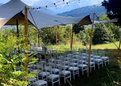 Chaises blanches sous tente avec vue montagne